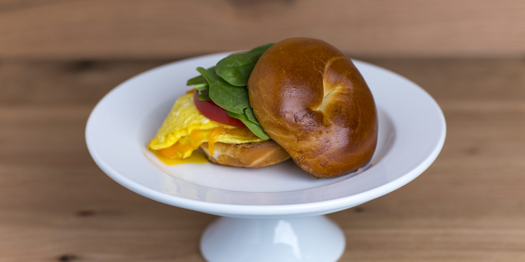 Bagel with eggs, spinach and tomato